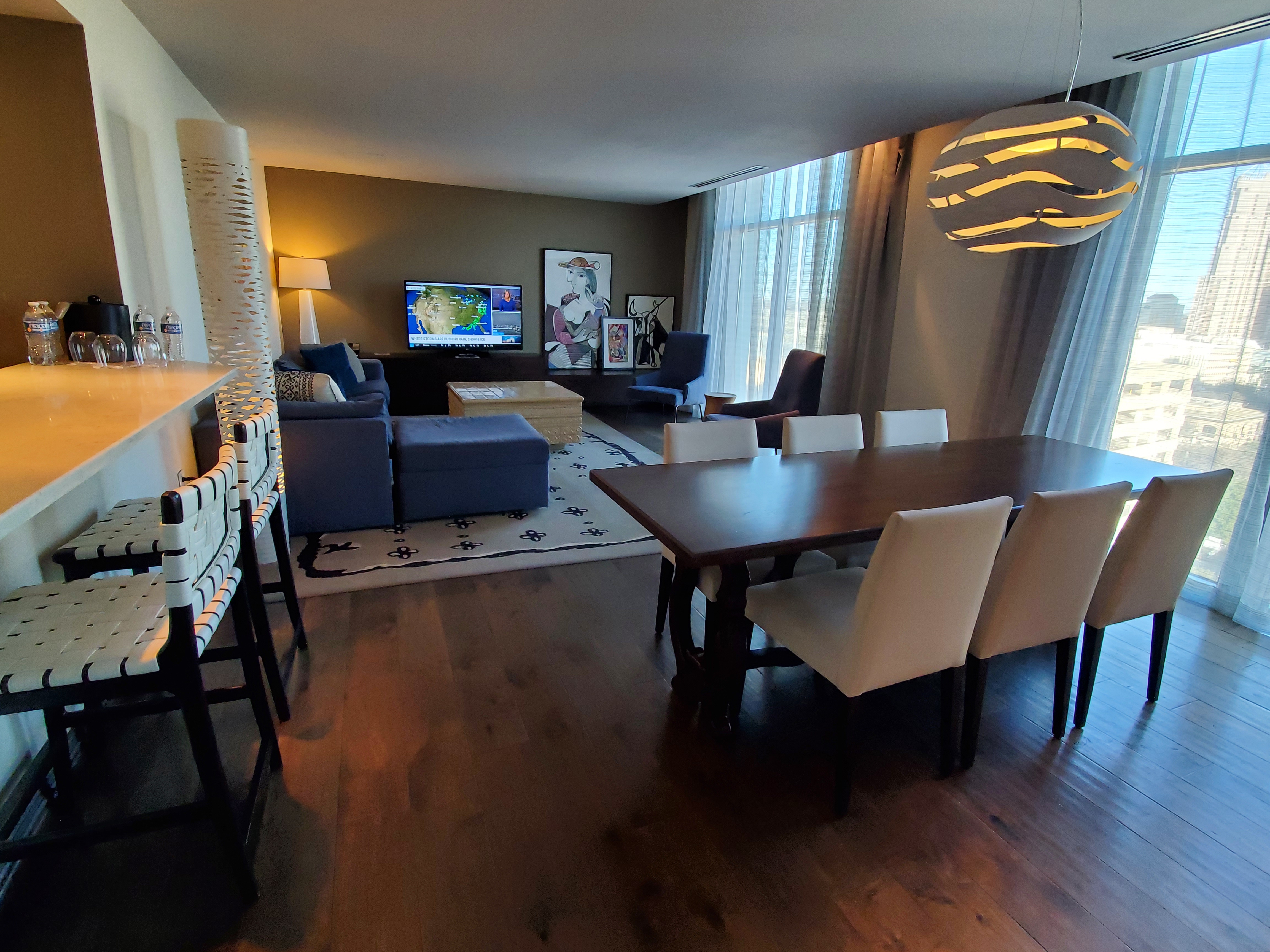 A wide view of a living room and dining area with modern furniture and decor.
